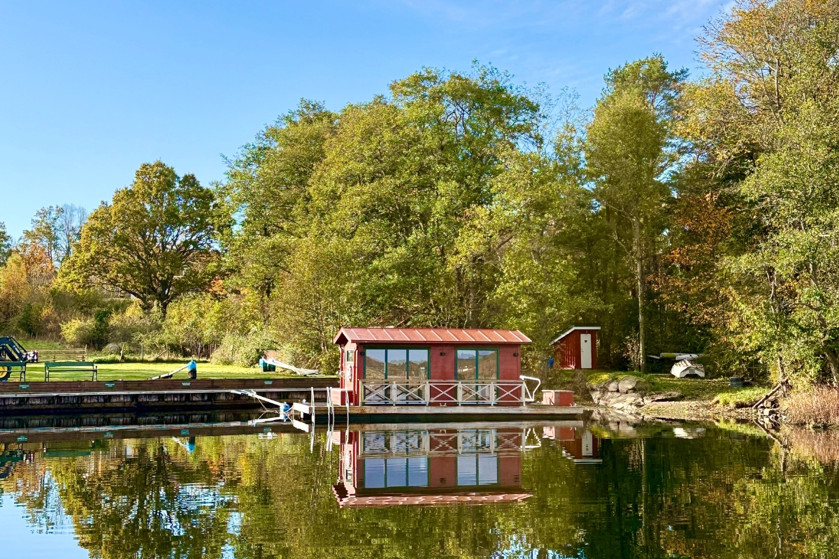 a small red building on a lake