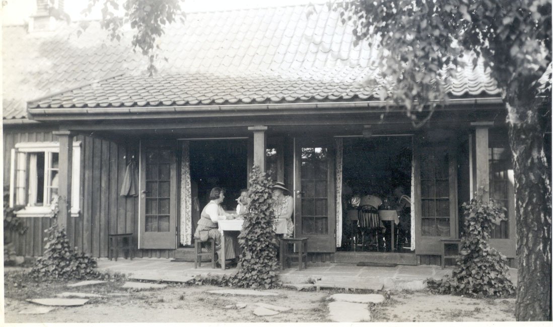 a group of people sitting at a table outside a house