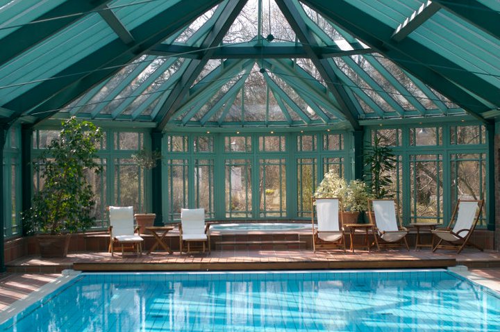a pool with chairs and a glass roof