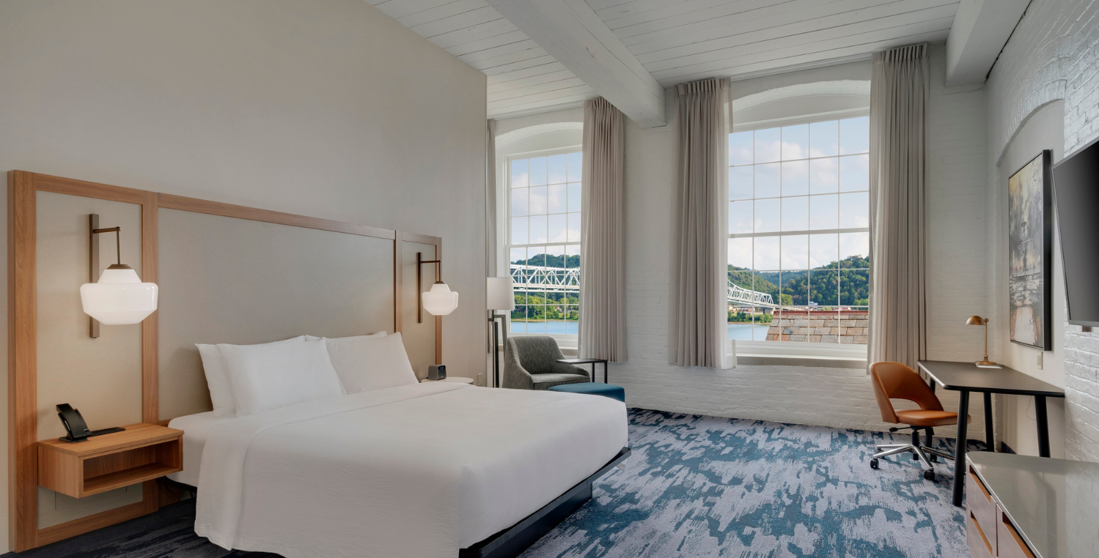 a room with a bed and a chair and a window