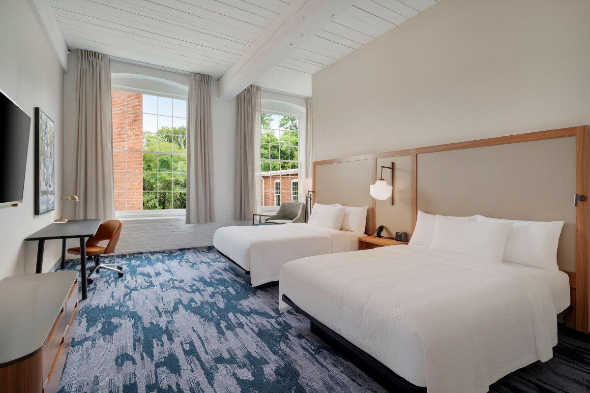 a room with two beds and a desk