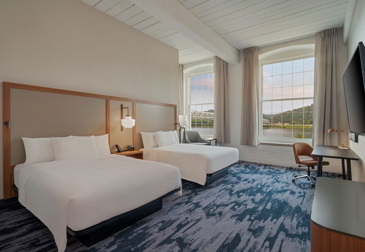 a room with two beds and a chair