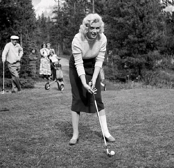 a woman playing golf on a course