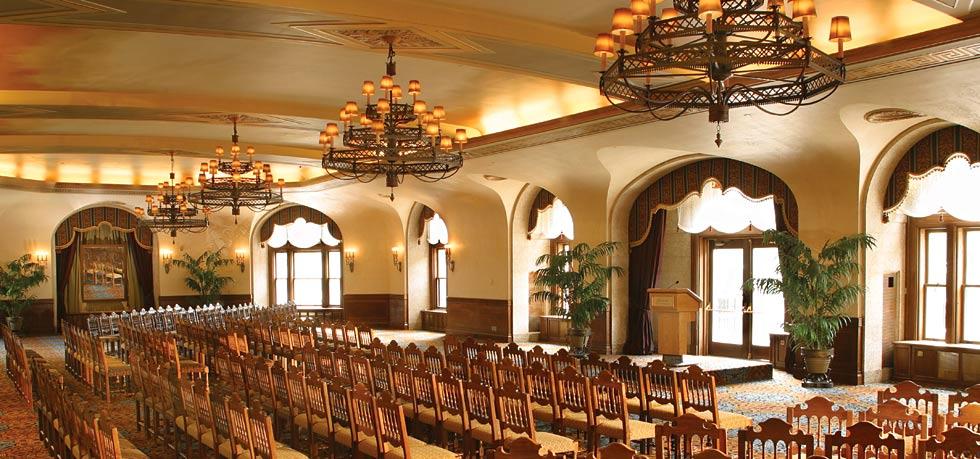 a room with chairs and chandeliers