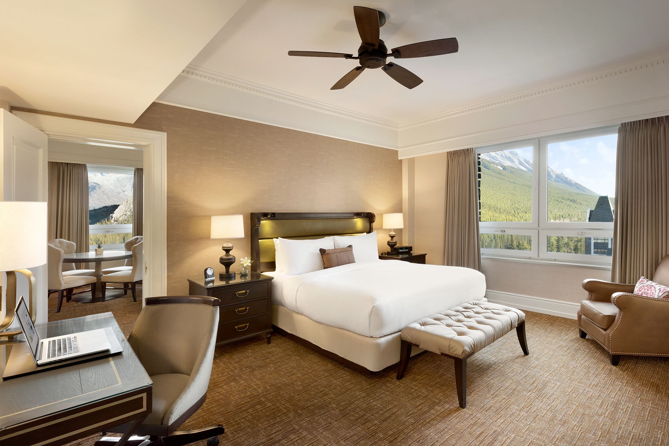 a room with a bed and a desk and a fan