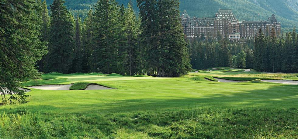 a golf course with trees and a building in the background