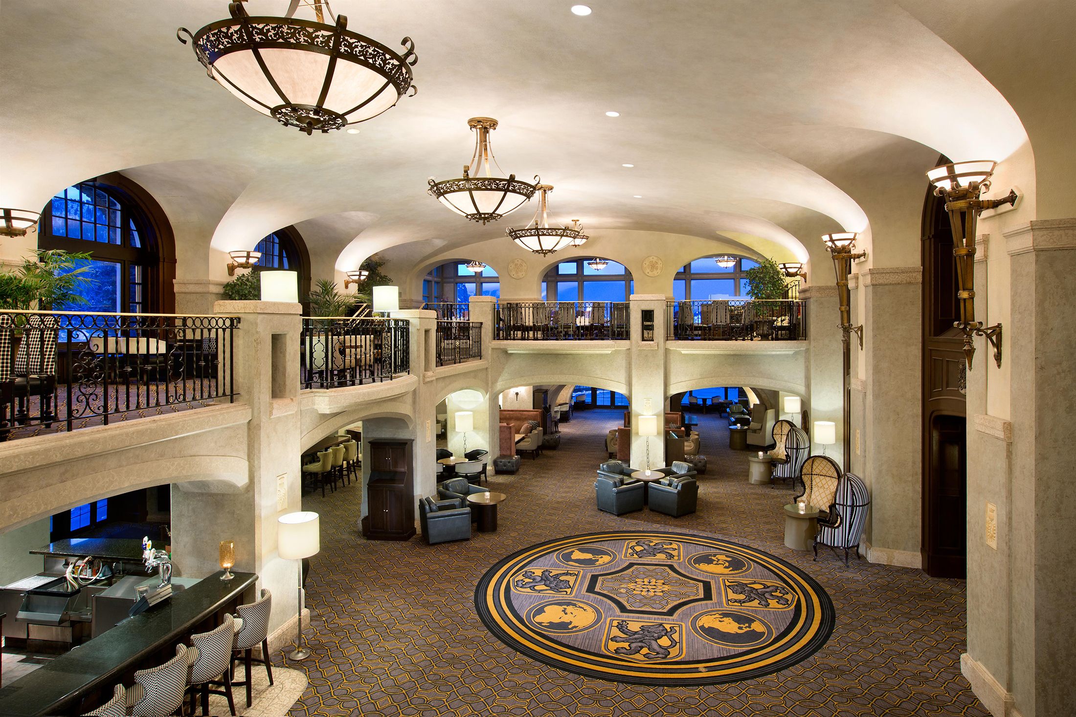 a large room with a round carpeted area and chandeliers