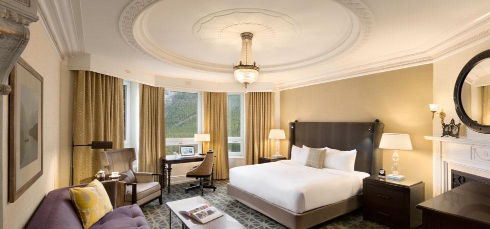 a room with a bed and chairs