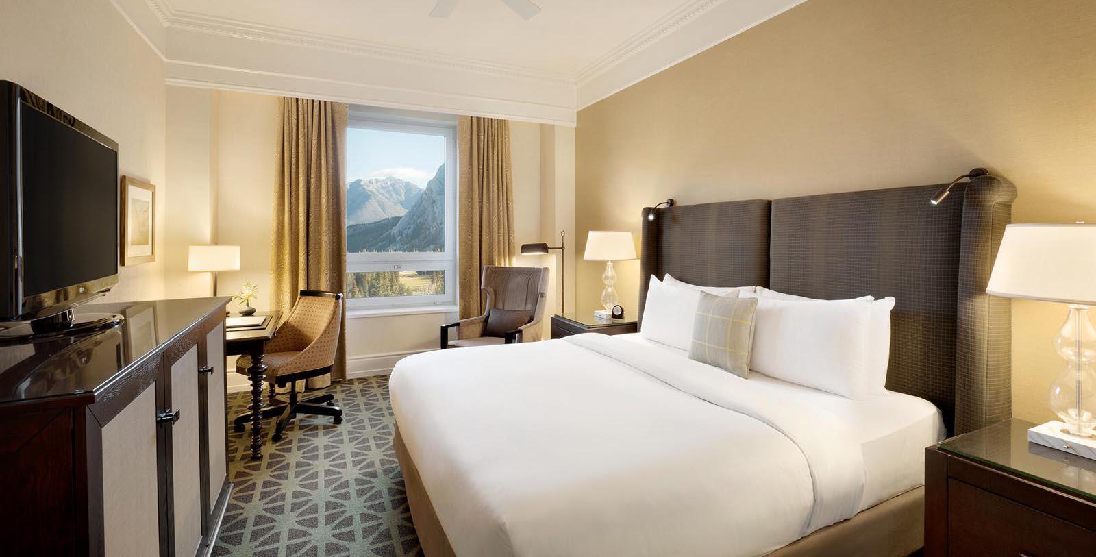 a hotel room with a large bed and chairs
