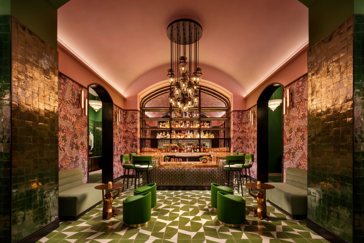 a room with a bar and green chairs