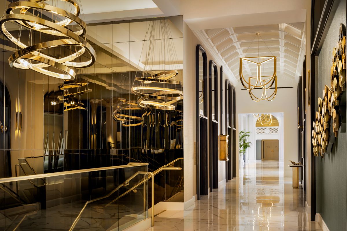 a hallway with chandeliers and railings