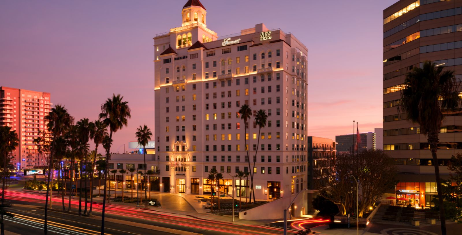a building with palm trees and a street in the background