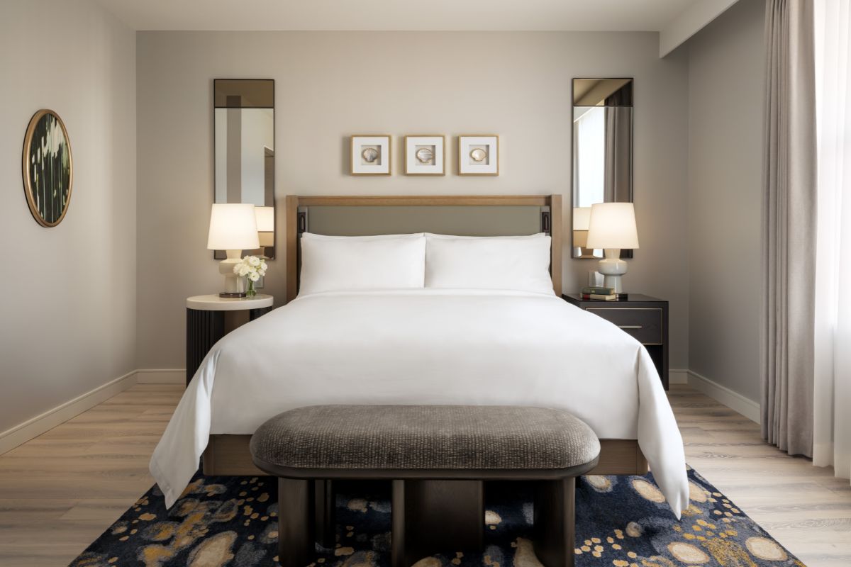a bed with a bench and lamps in a room