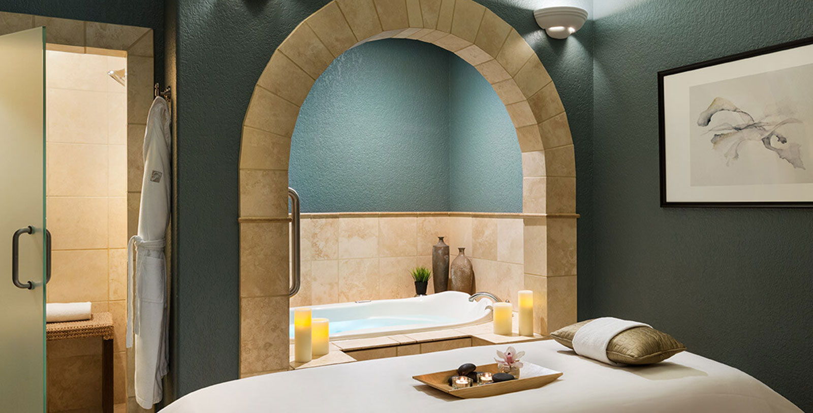 a bathtub with candles and a tray on it