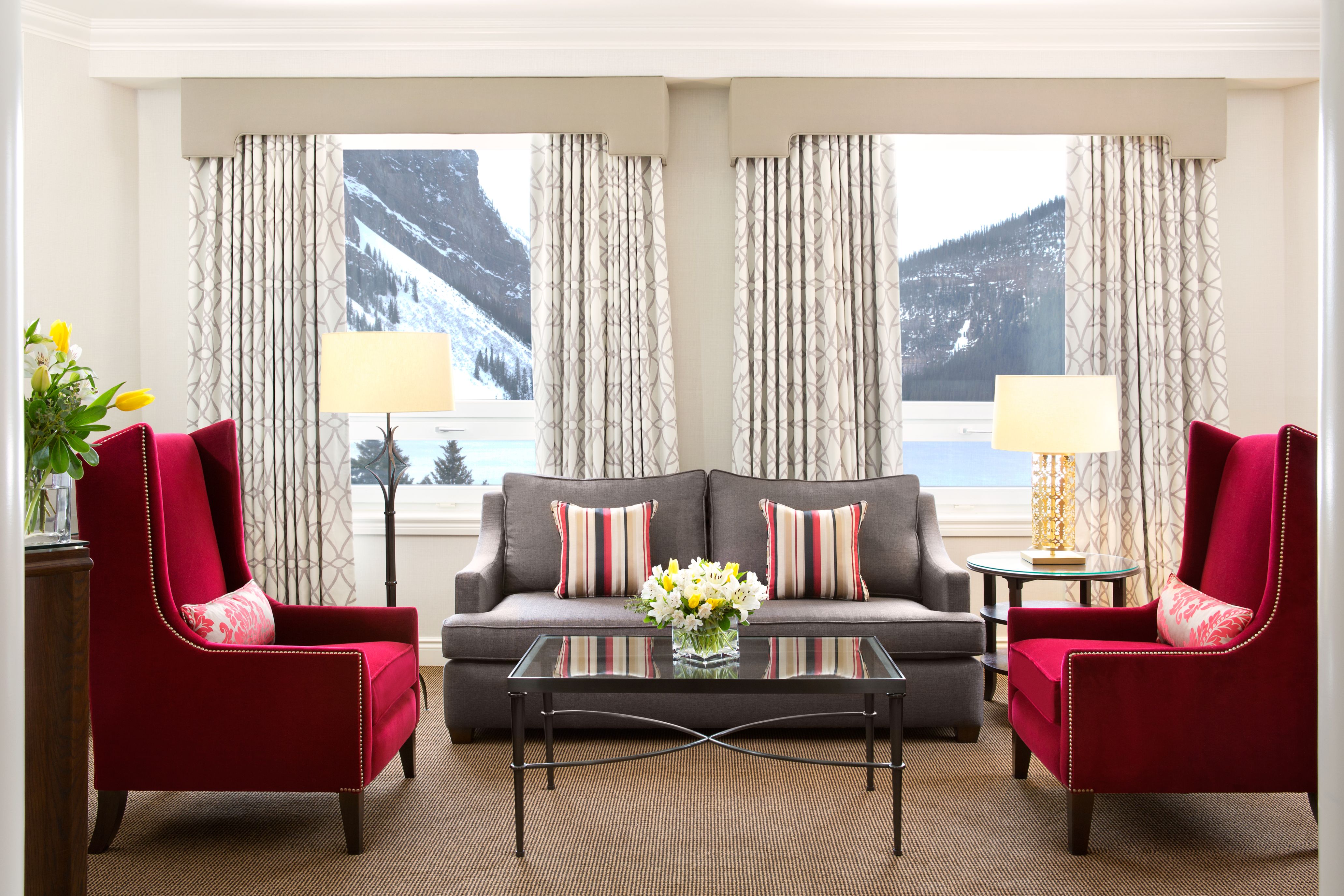a living room with red chairs and a table