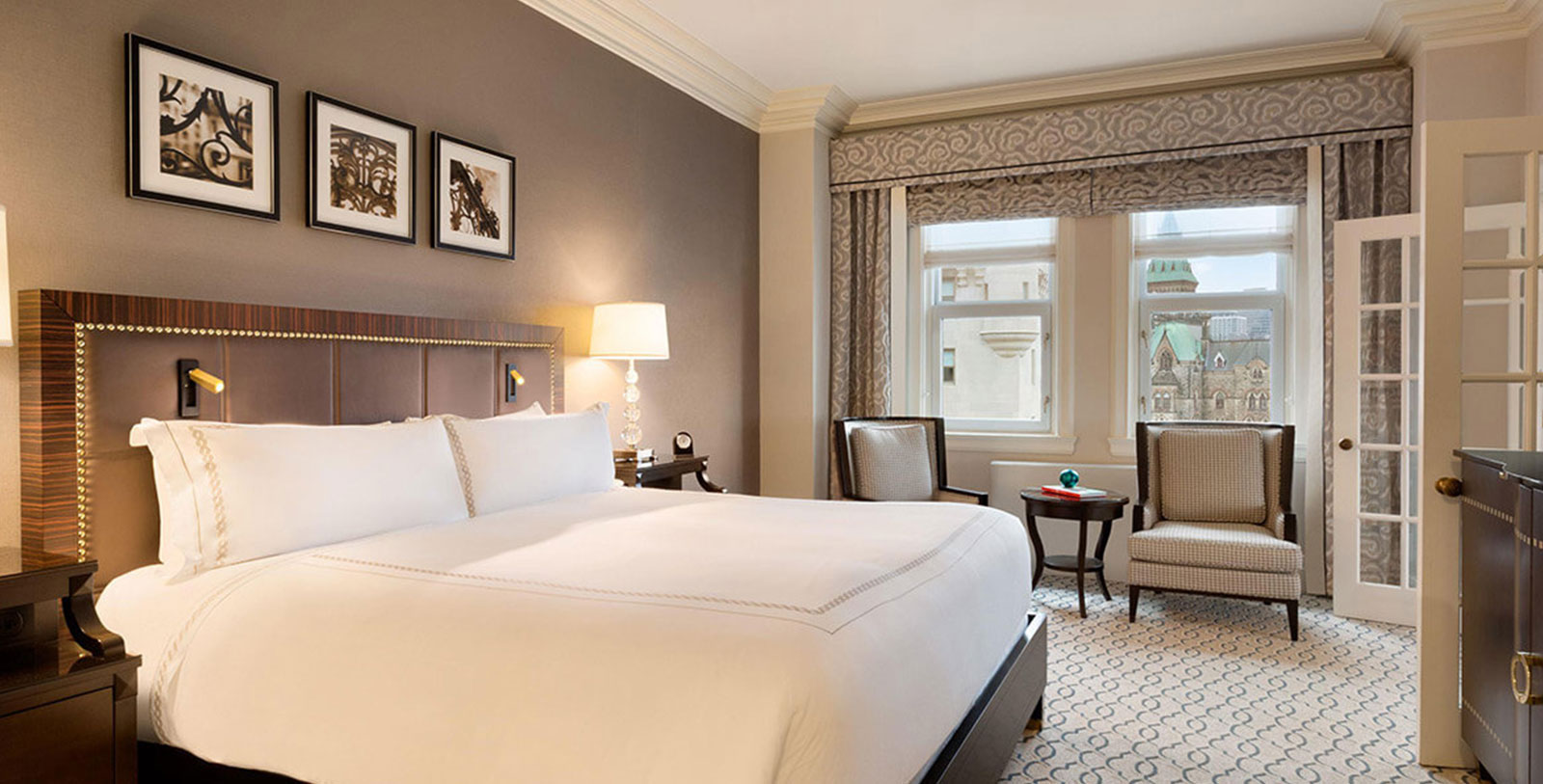 a room with a bed and chairs