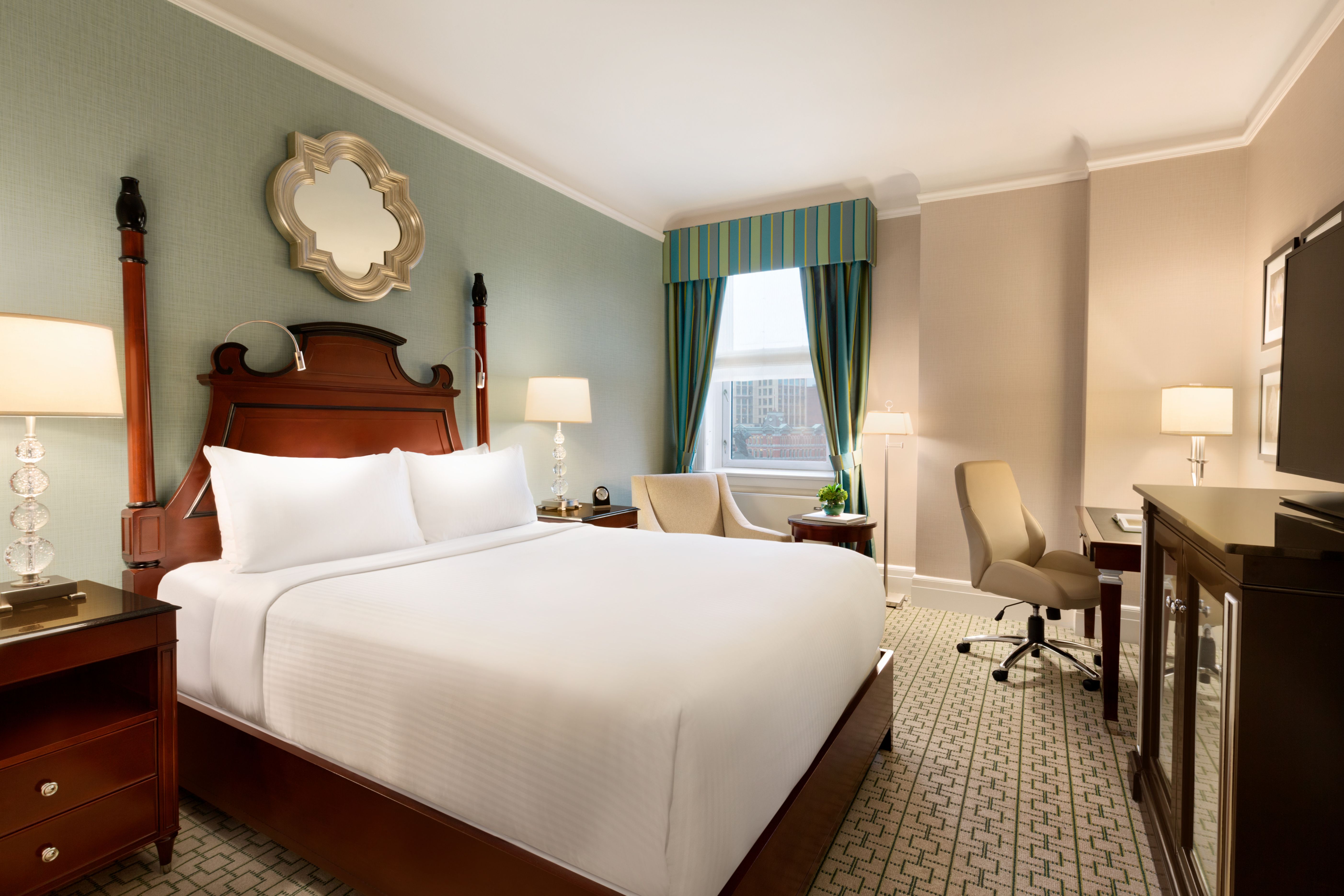 a room with a bed and a desk and chair