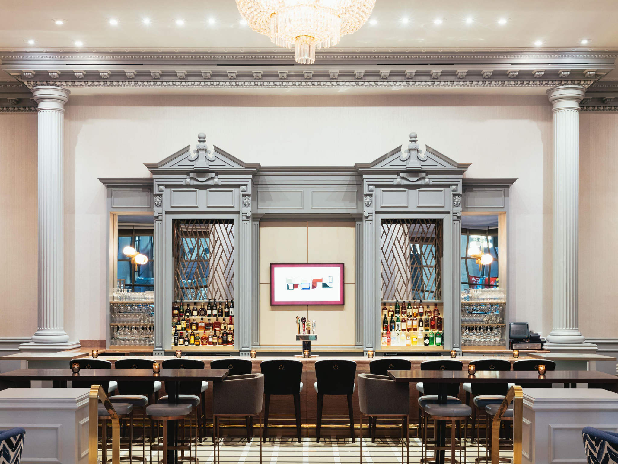 a bar with a chandelier and chairs