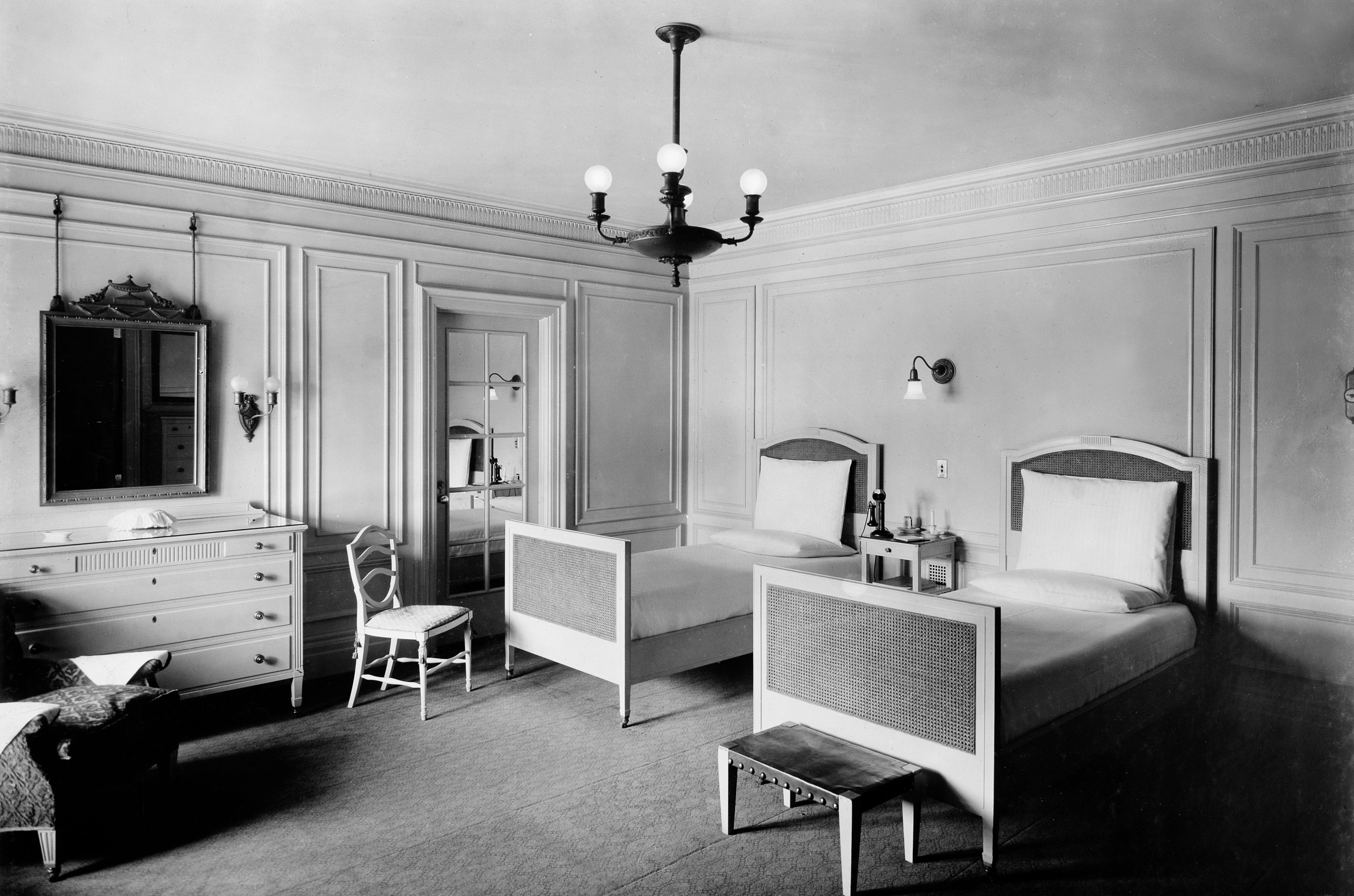 a bedroom with two beds and a chandelier
