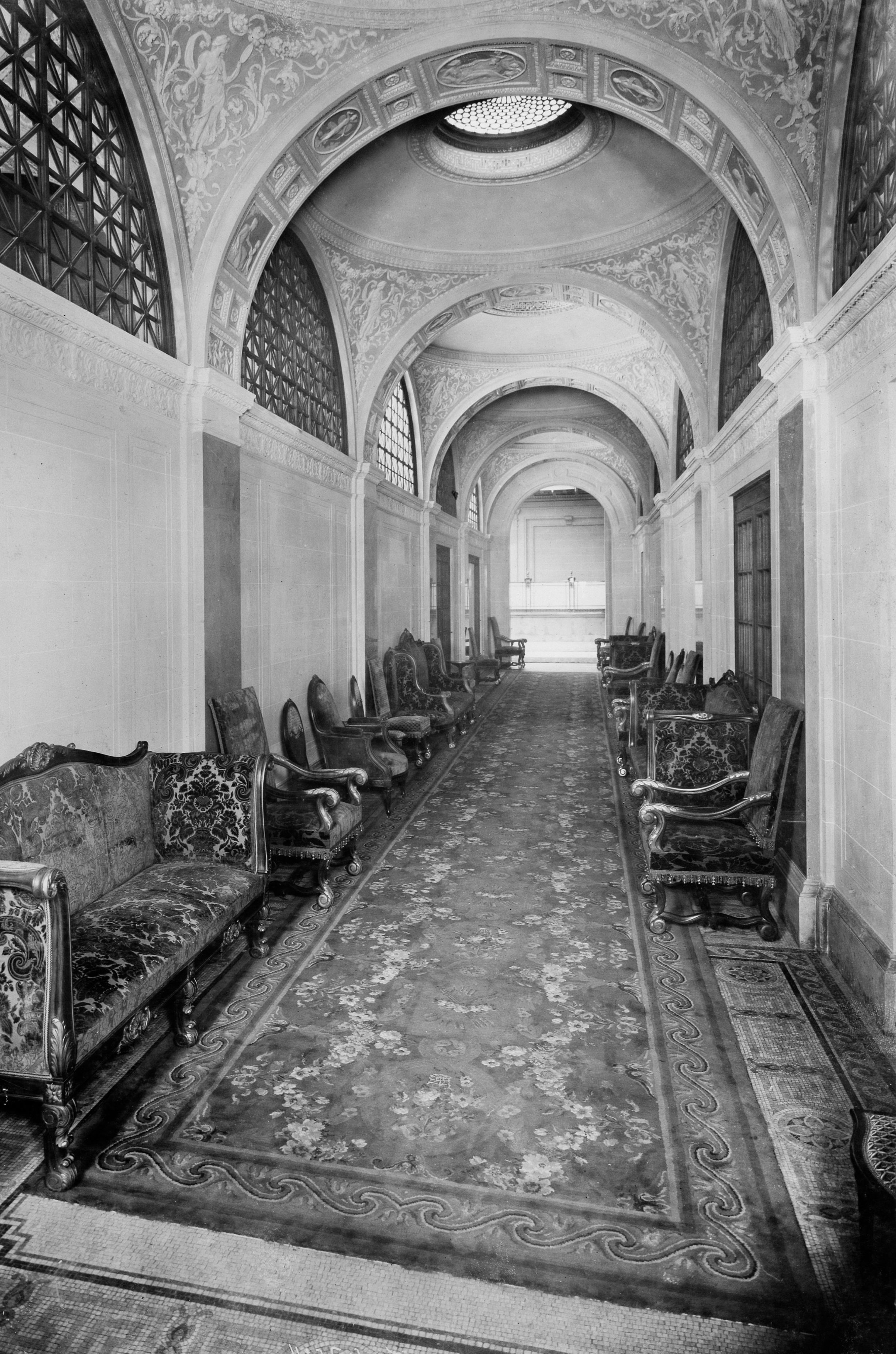 a long hallway with chairs and a carpet
