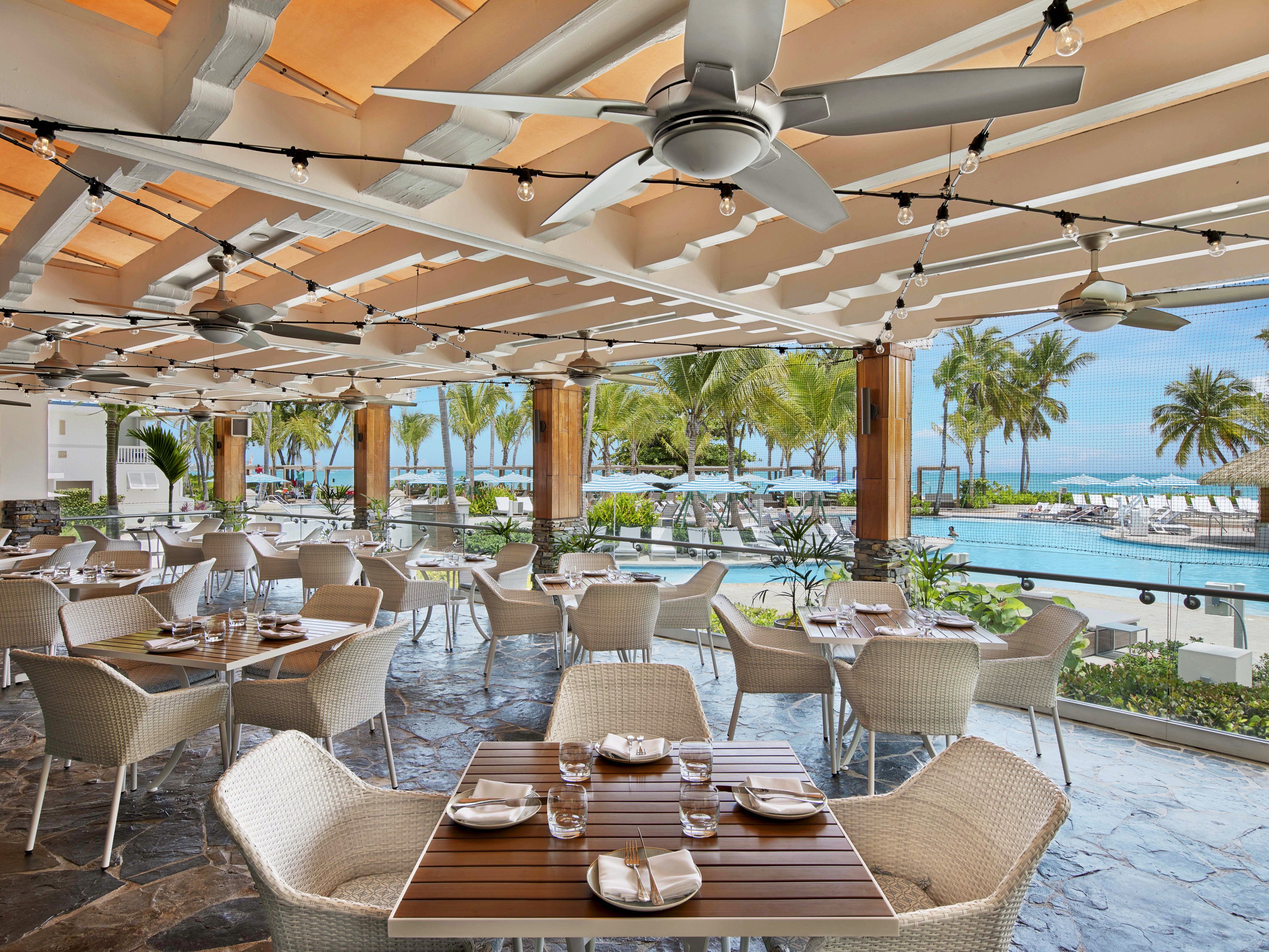 a restaurant with tables and chairs and a pool