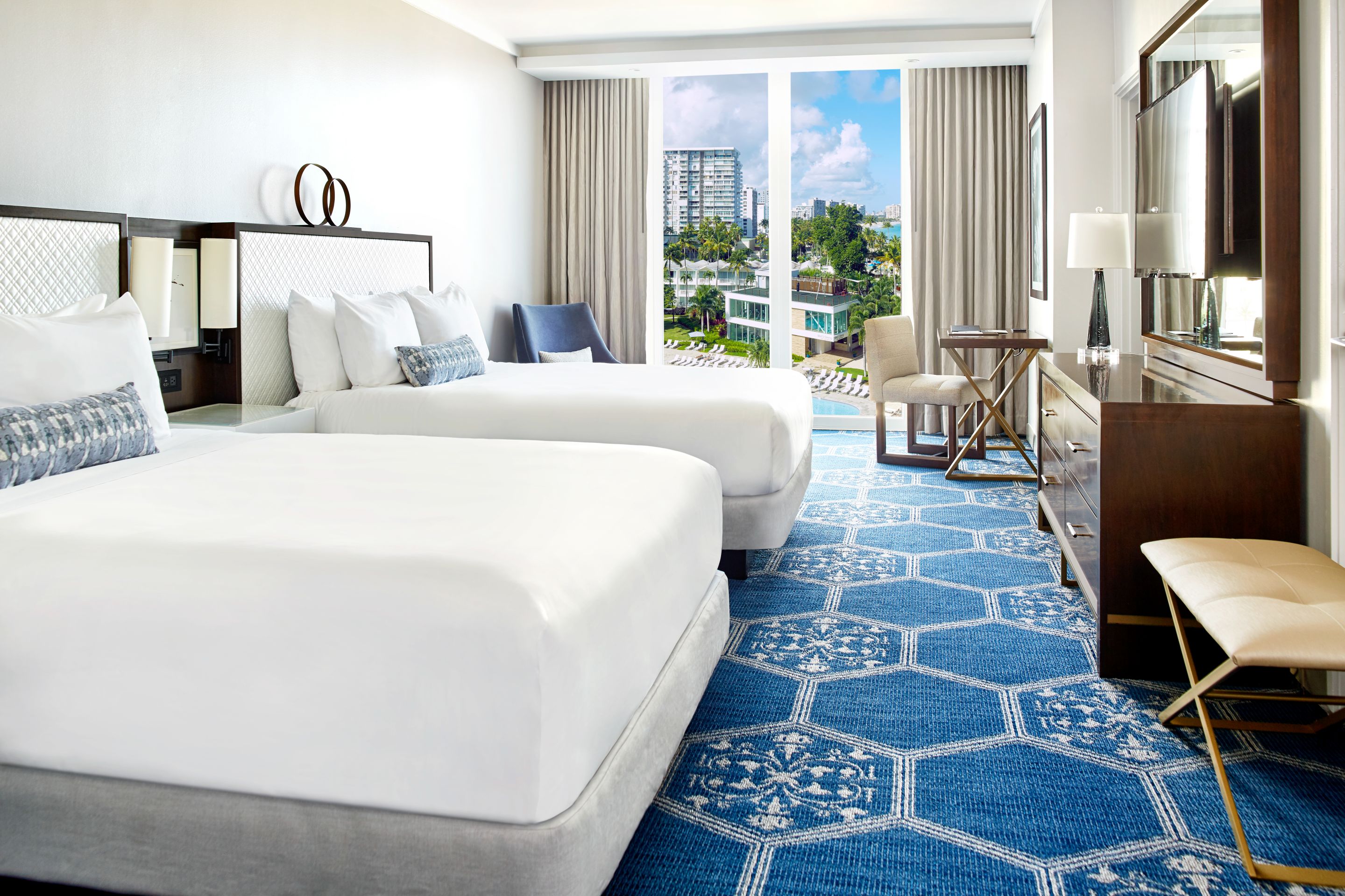 a room with two beds and a dresser