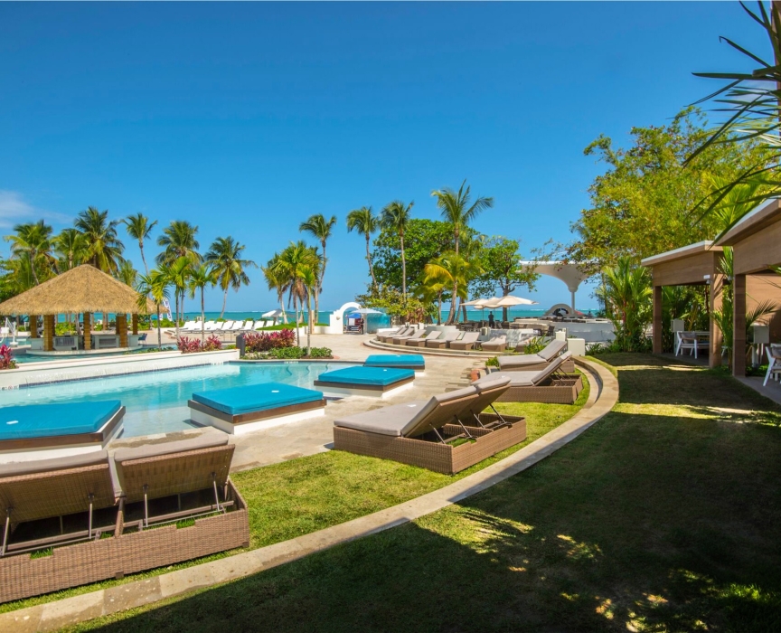 a pool with lounge chairs and a beach umbrella