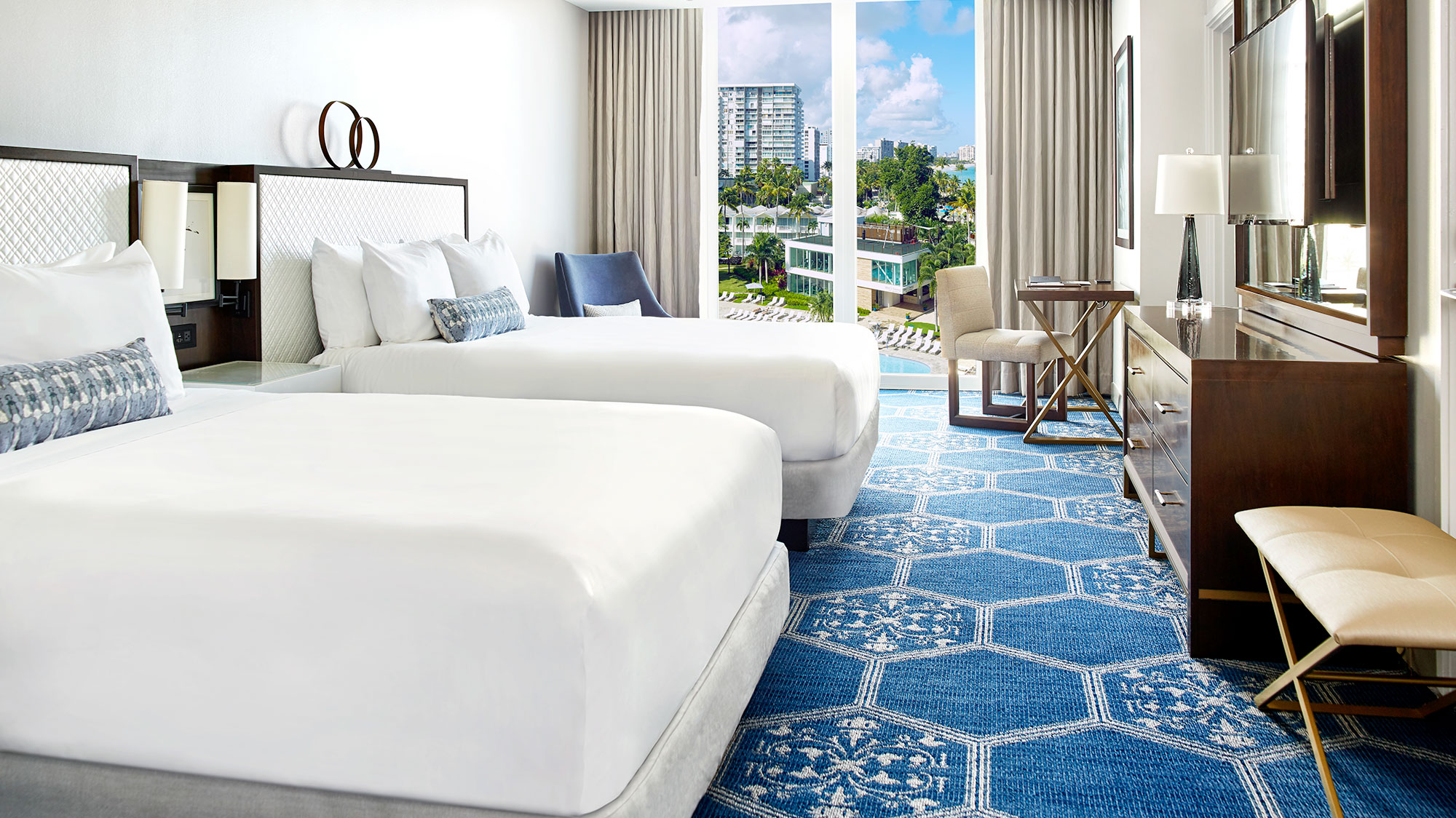 a room with two beds and a blue rug