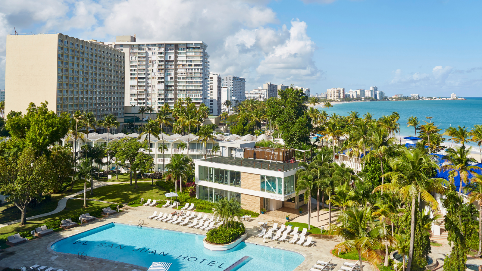 a pool and buildings with palm trees and buildings in the background