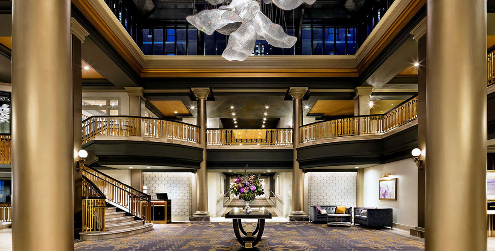 a large room with a large chandelier and a vase of flowers
