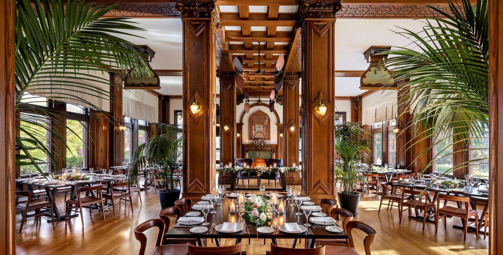 a room with a large table set with plates and flowers