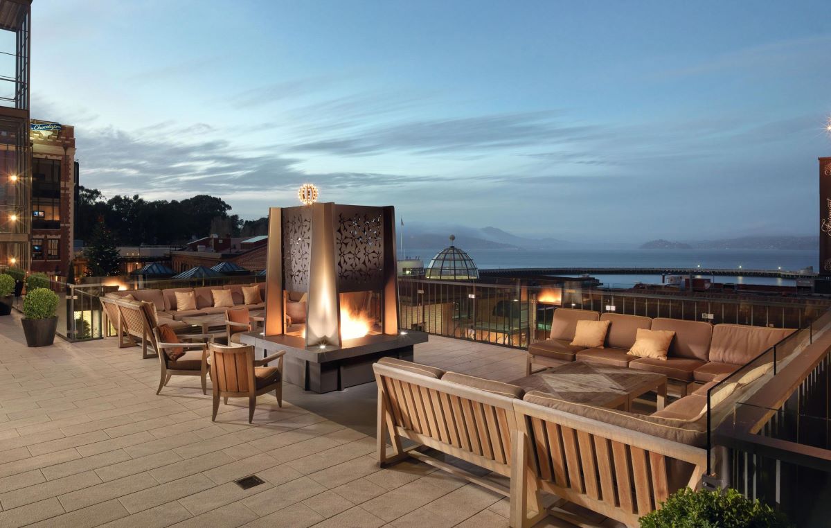 a patio with a fire pit and chairs