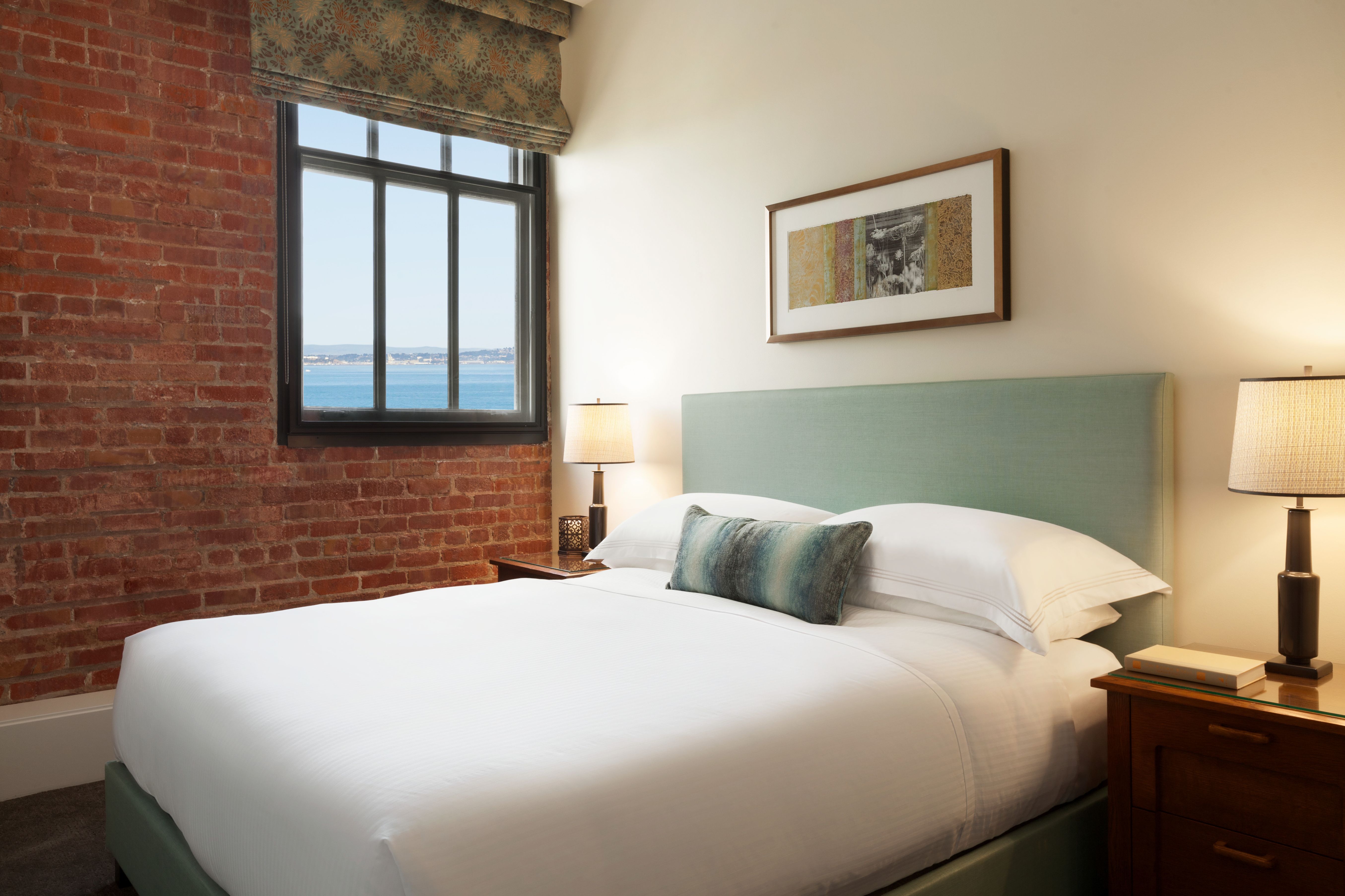 a bed with a window and a brick wall
