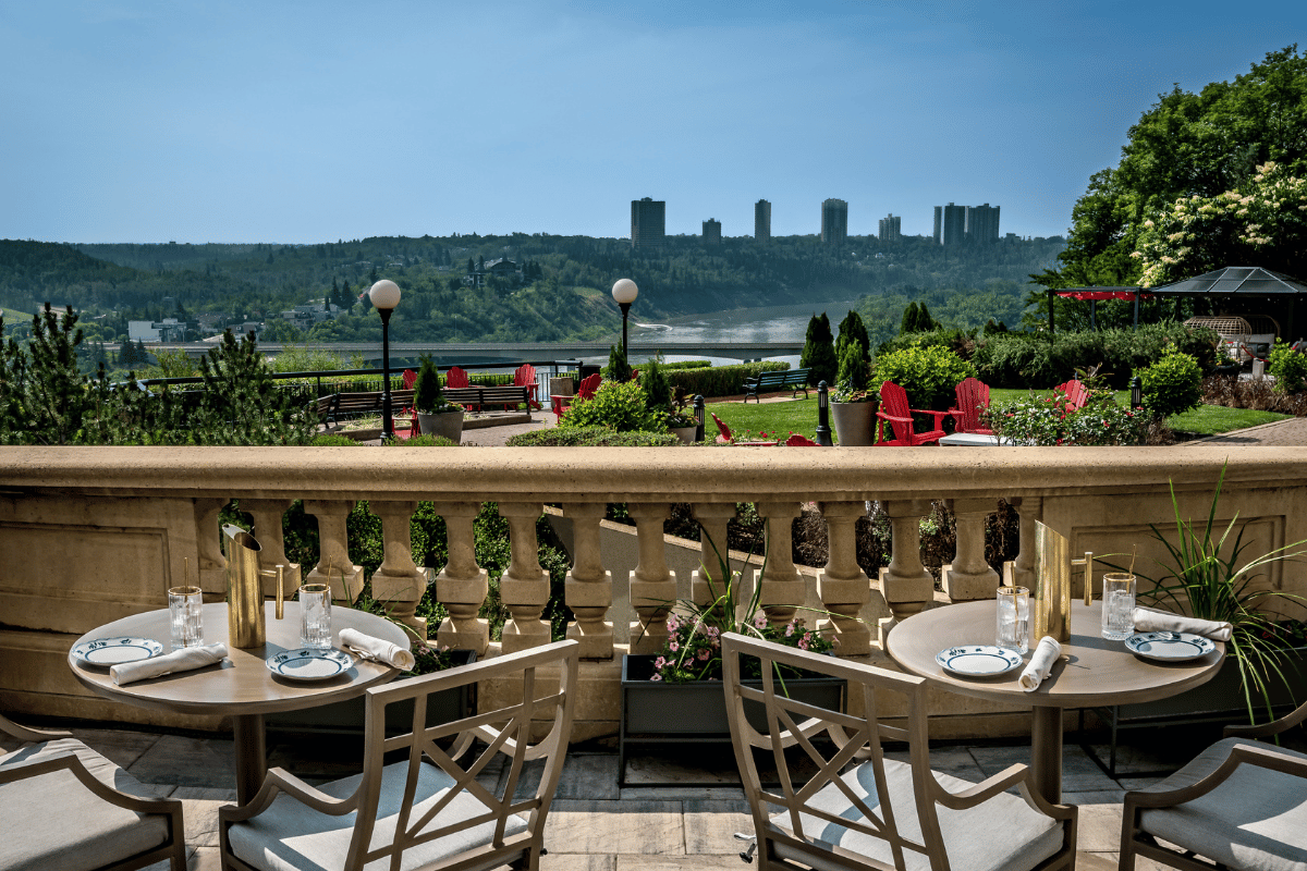 a table and chairs on a balcony overlooking a city