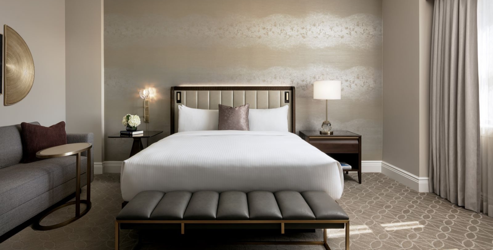 a bed with a bench and lamps