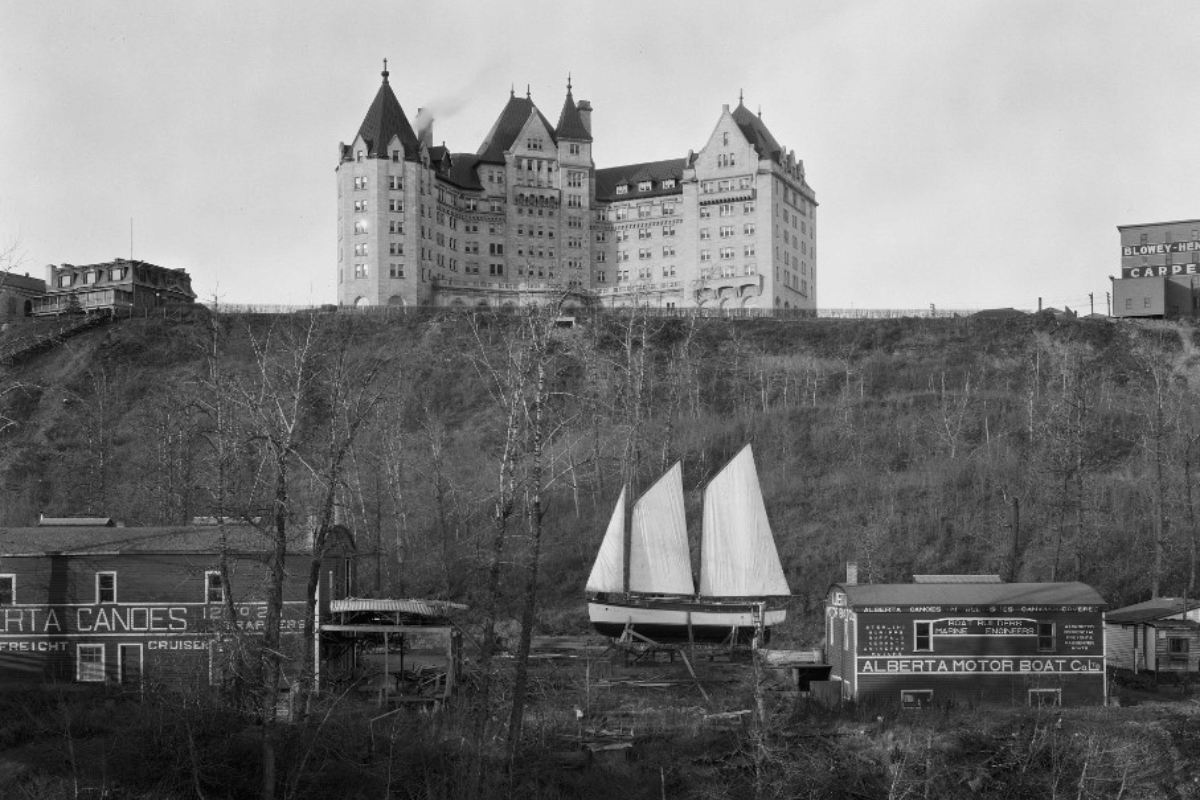 a large building with a sailboat on the hill