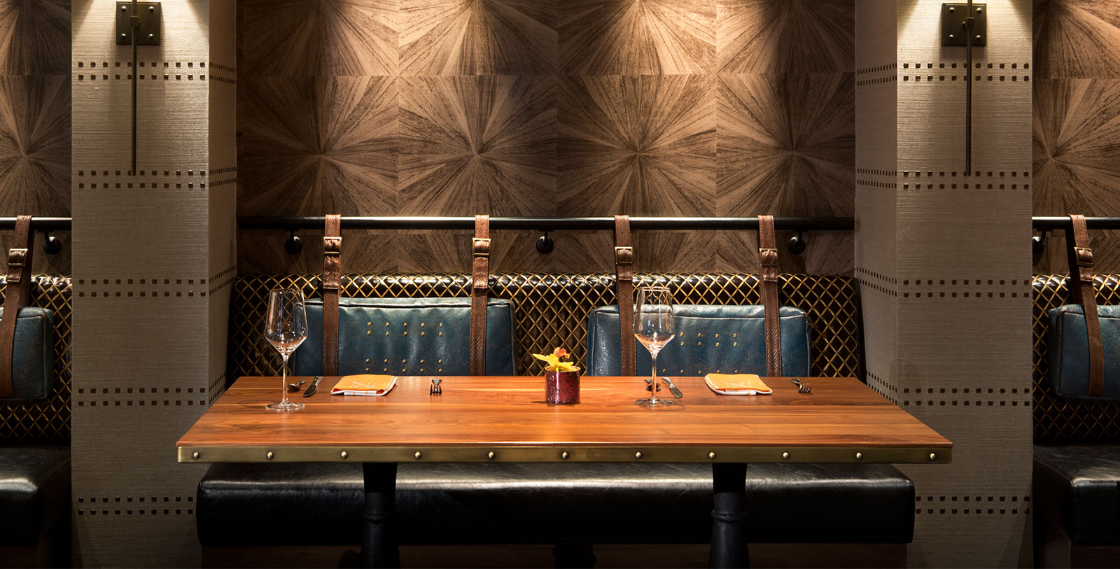 a table with wine glasses and a chair in front of a wall