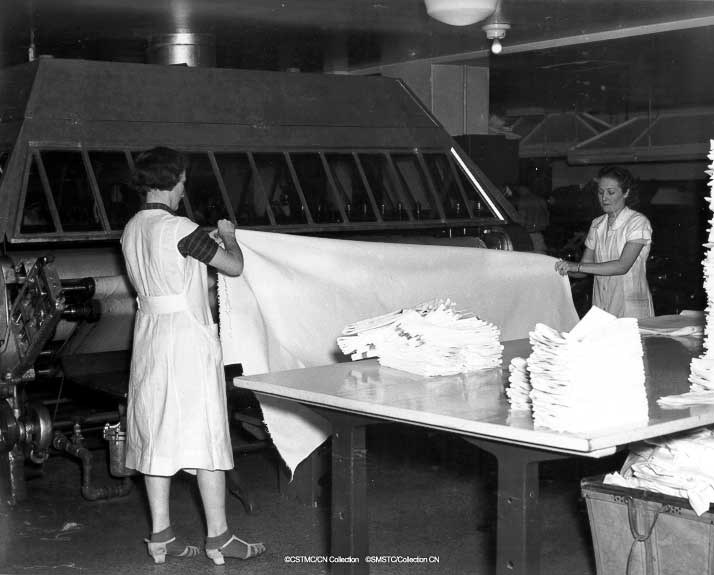 women in a factory folding a sheet of paper
