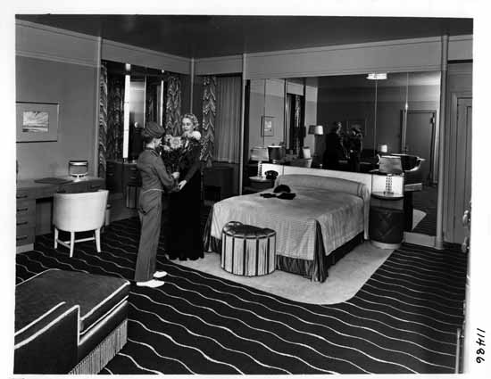 a man giving a woman a bouquet of flowers to a bed