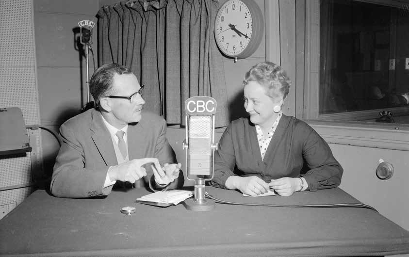 a man and woman sitting at a table with a microphone