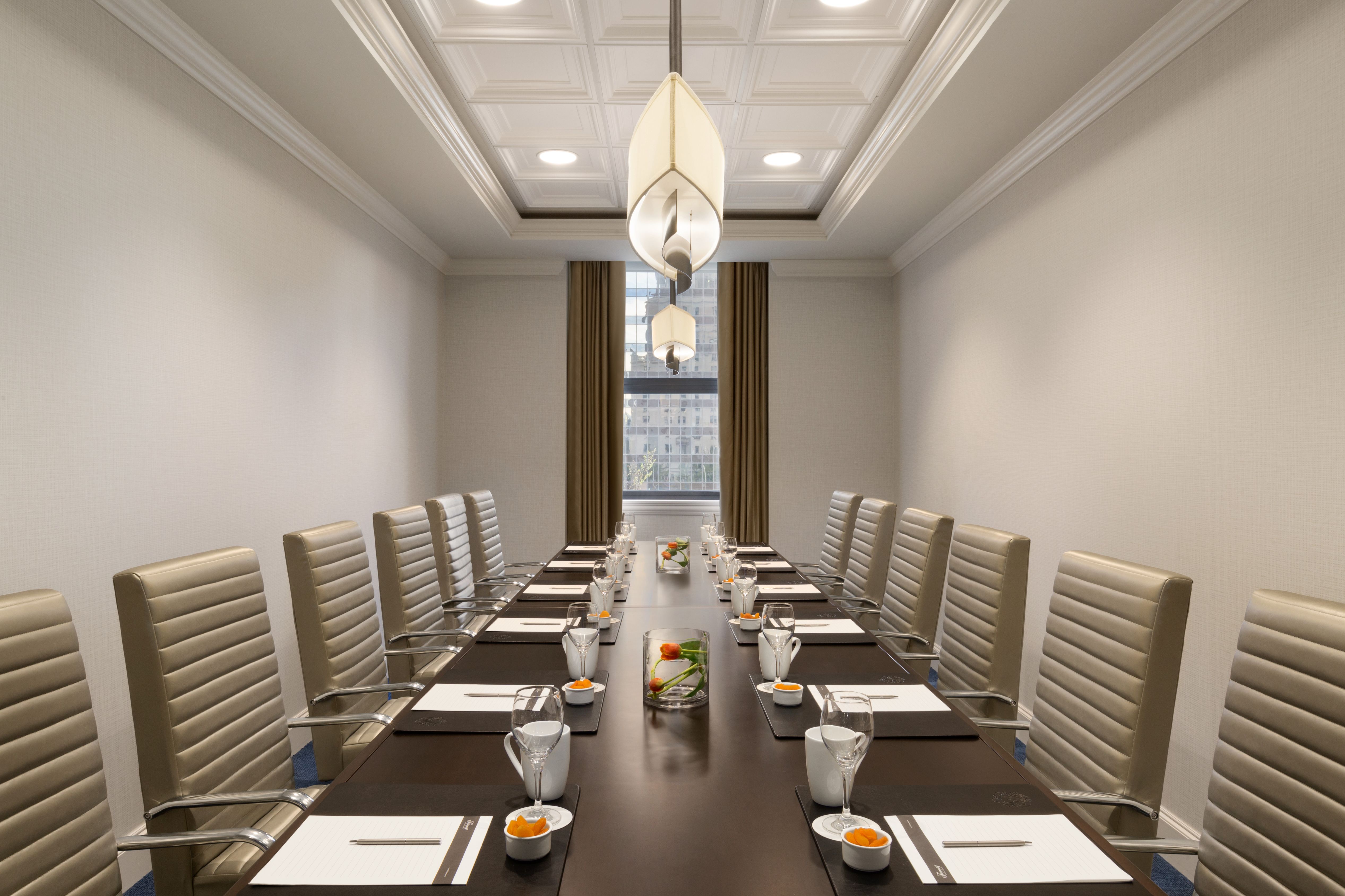 a long conference table with chairs and a lamp