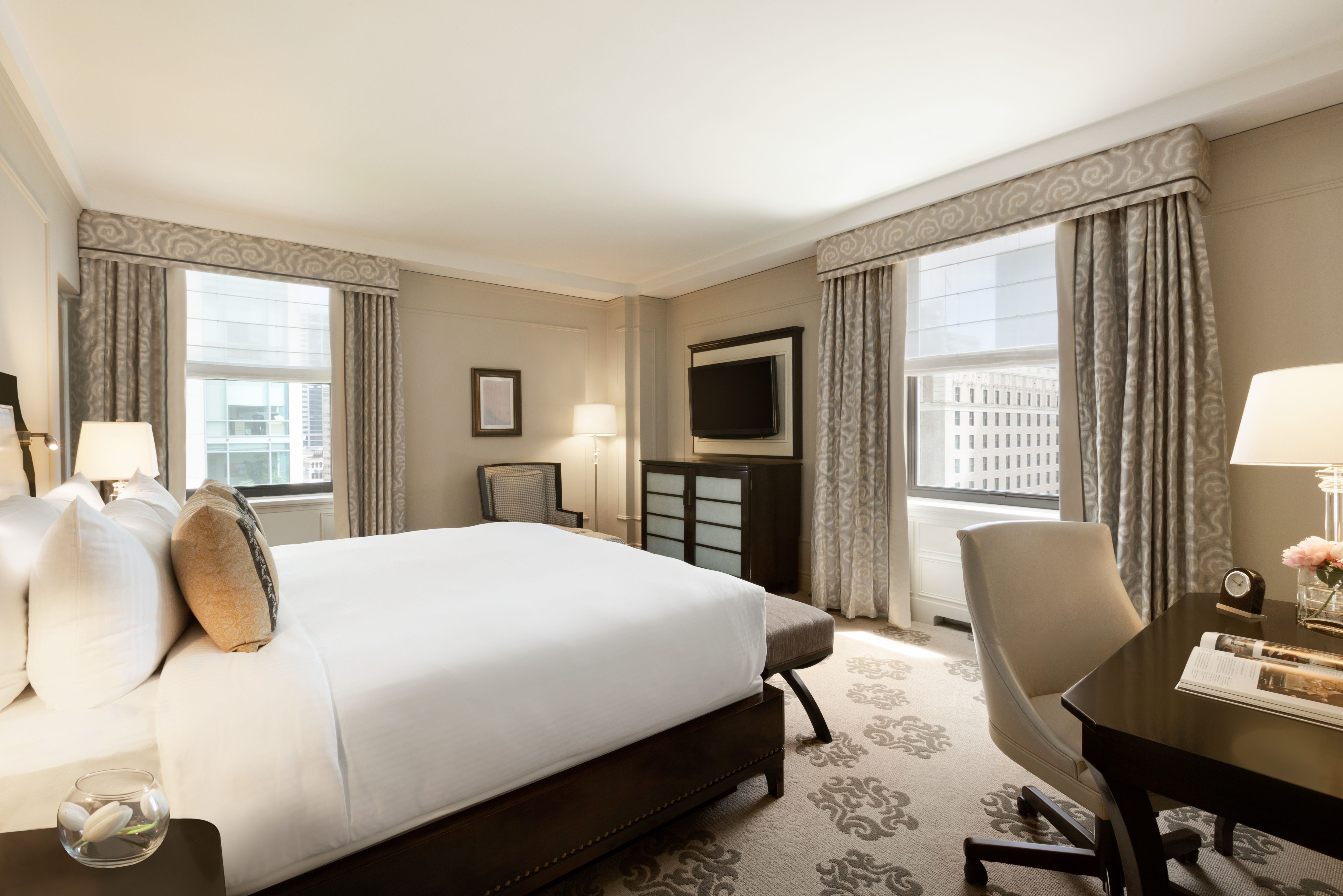 a room with a bed and chairs