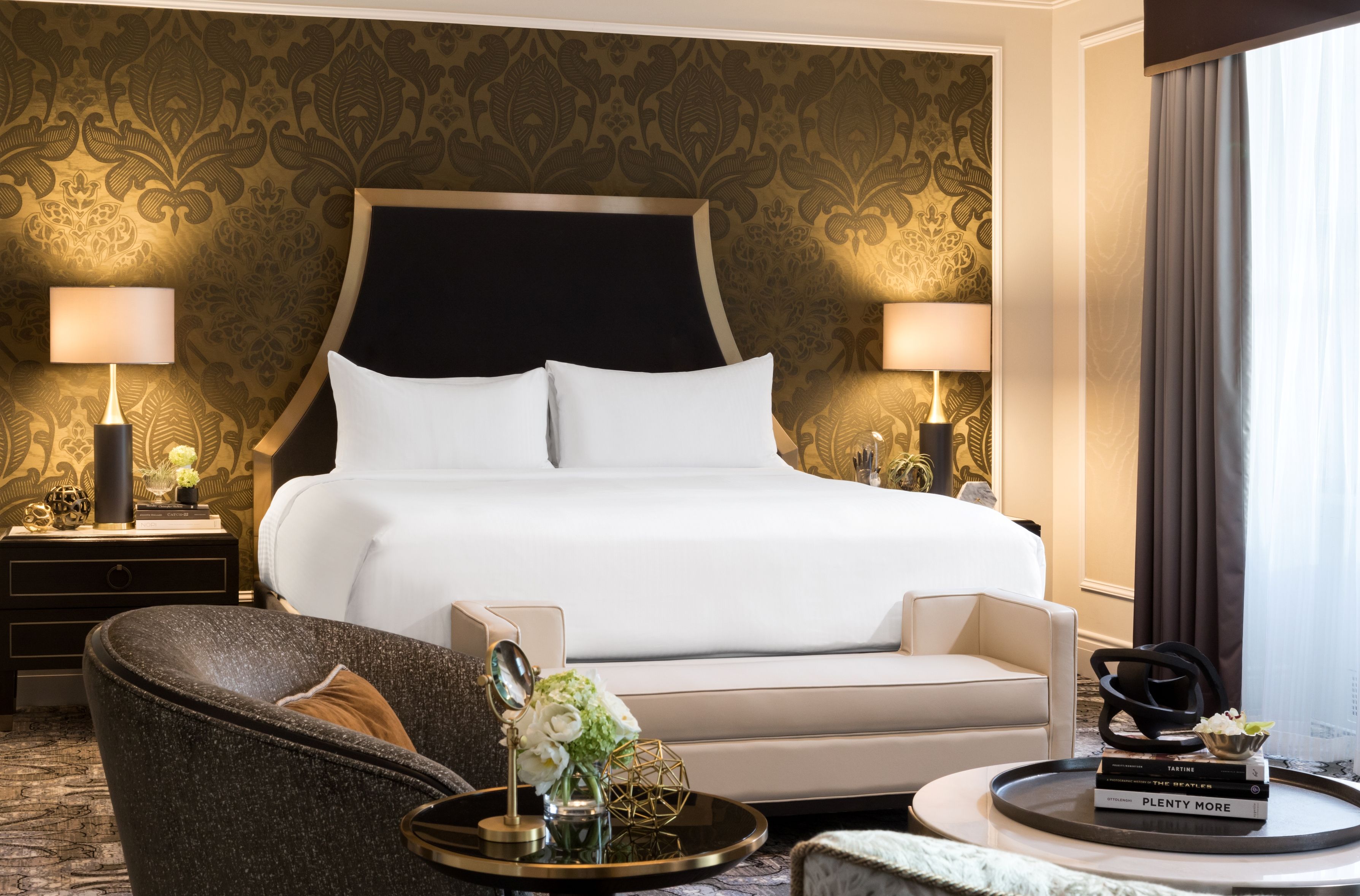 a room with a bed and chairs