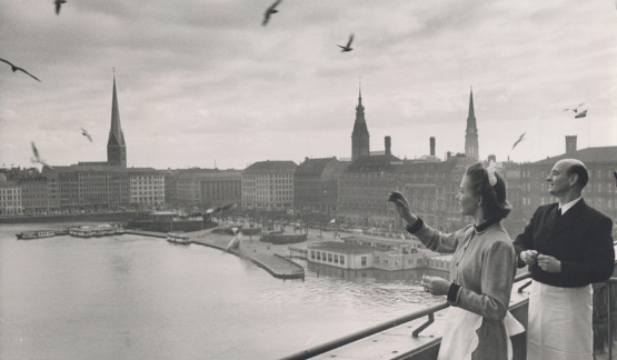 a woman standing on a balcony overlooking a river