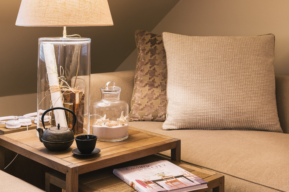 a table with a lamp and a glass jar on it