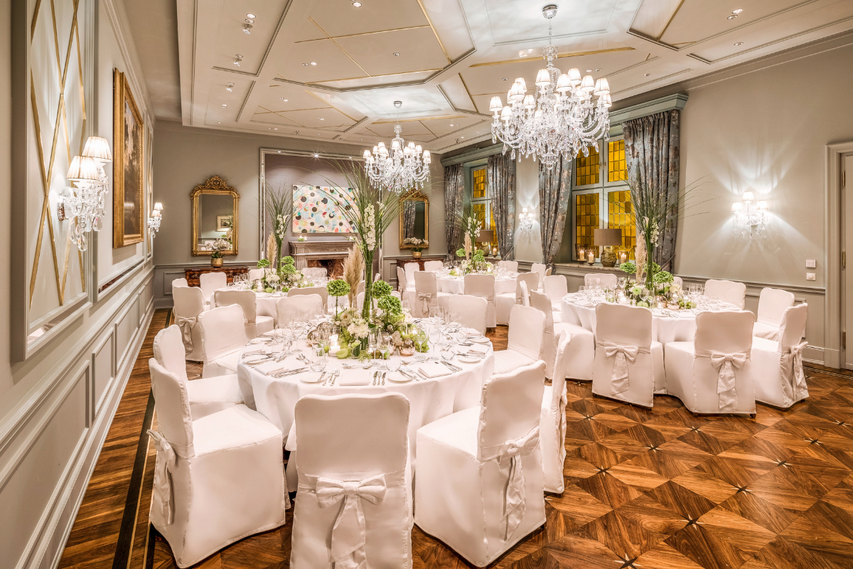 a room with white chairs and tables