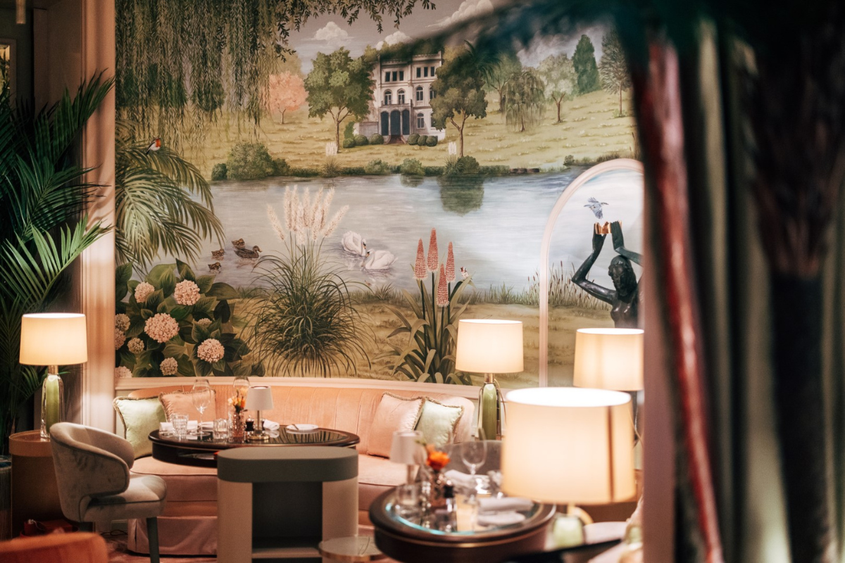 a room with a wall mural and tables and chairs