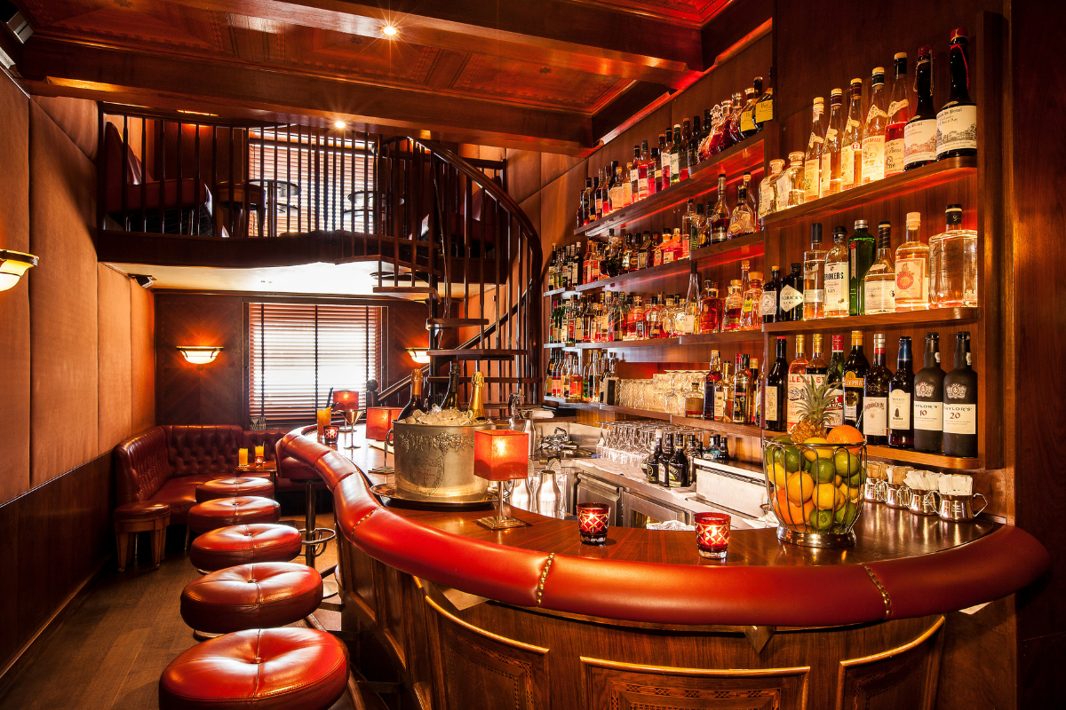 a bar with a spiral staircase and bottles of alcohol
