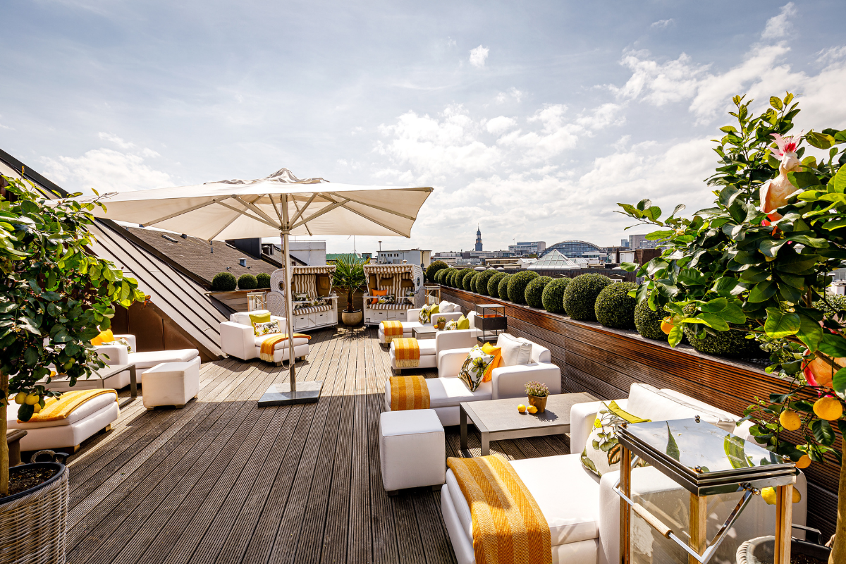 a patio with white furniture and umbrellas