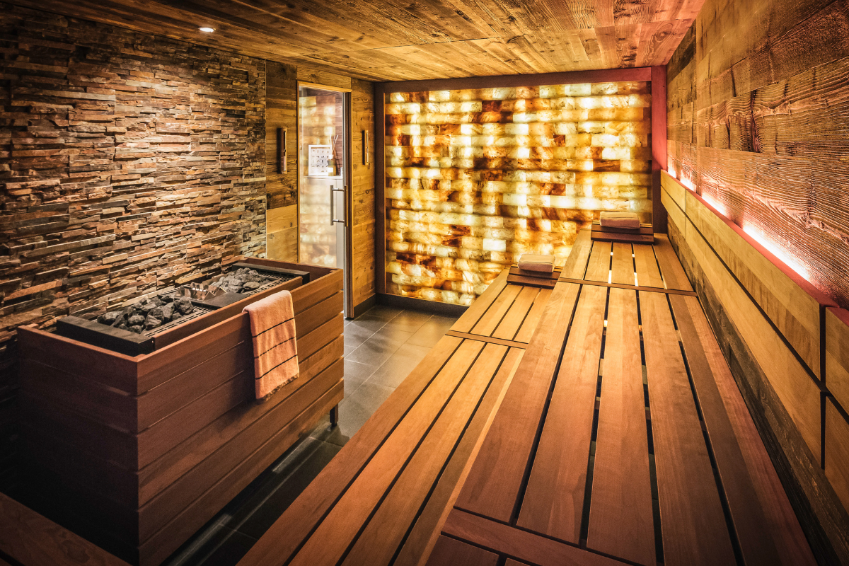 a sauna with a wood bench and a hot tub